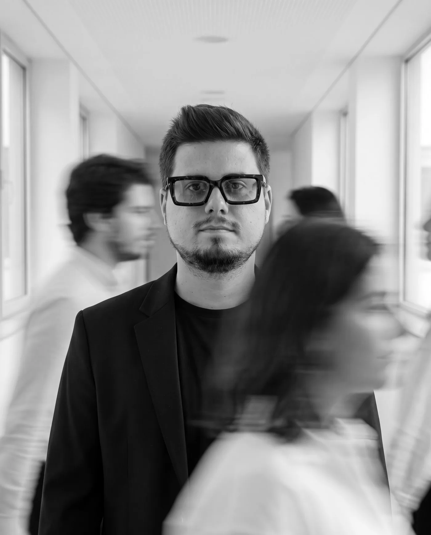 Guilherme Jasmins, fundador da Jasmins Studio, num corredor com pessoas em movimento